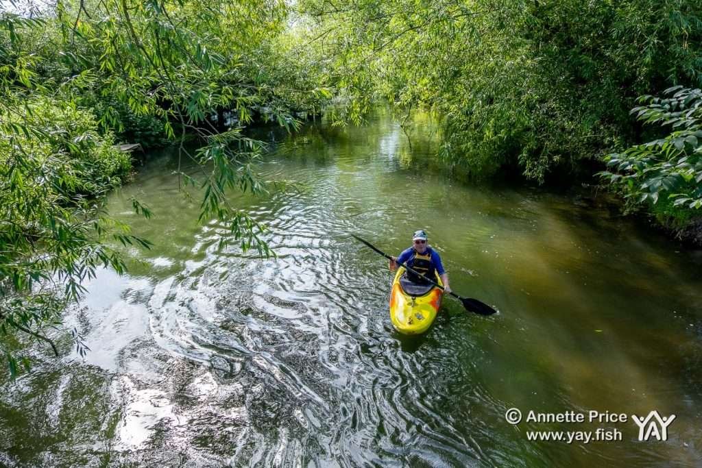 A kayak paddler enjoying St Patrick's Stream, near Shiplake, UK.